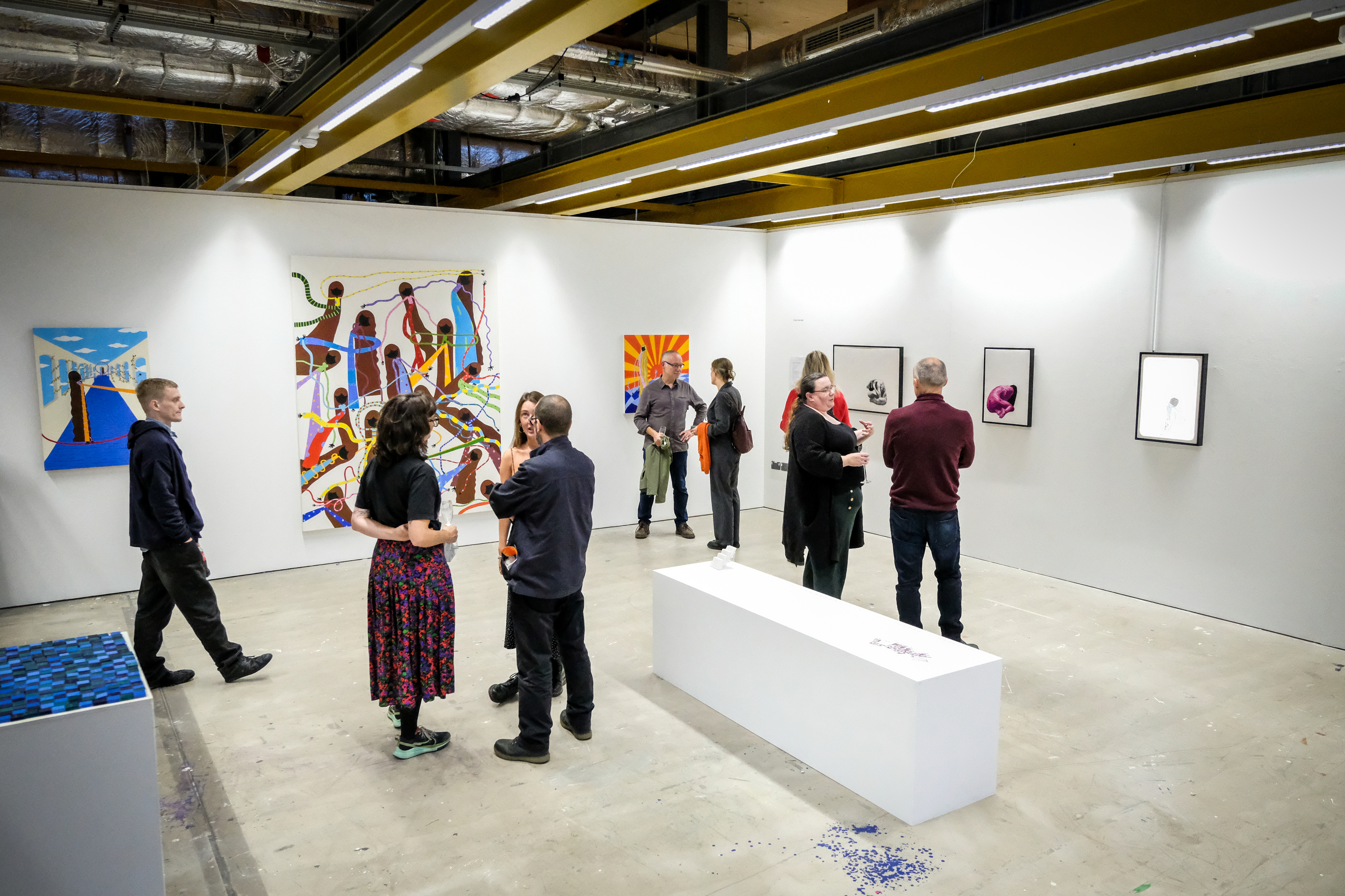 An art gallery with people milling around