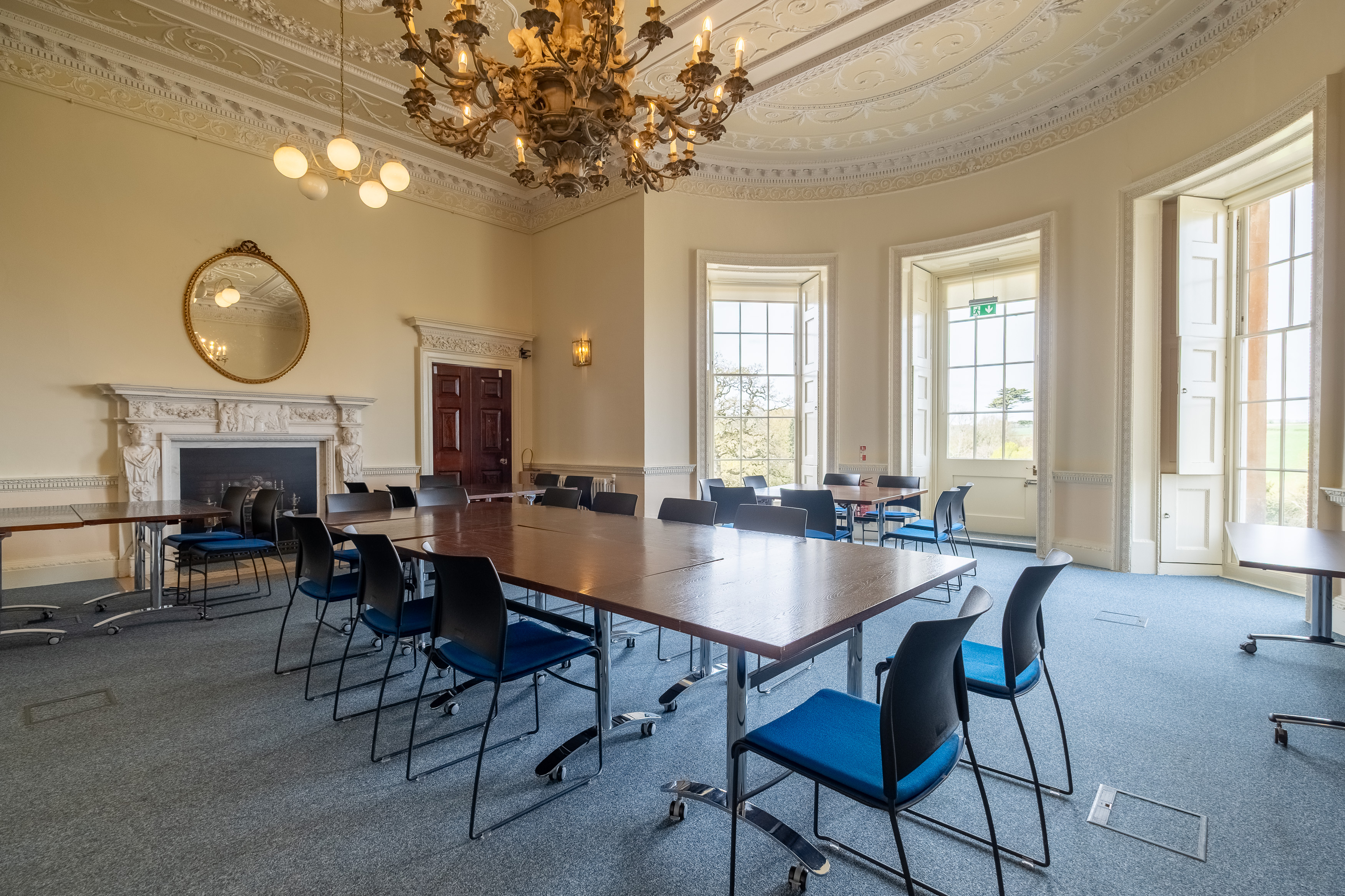 A large, brightly lit meeting room with a conference table and period features
