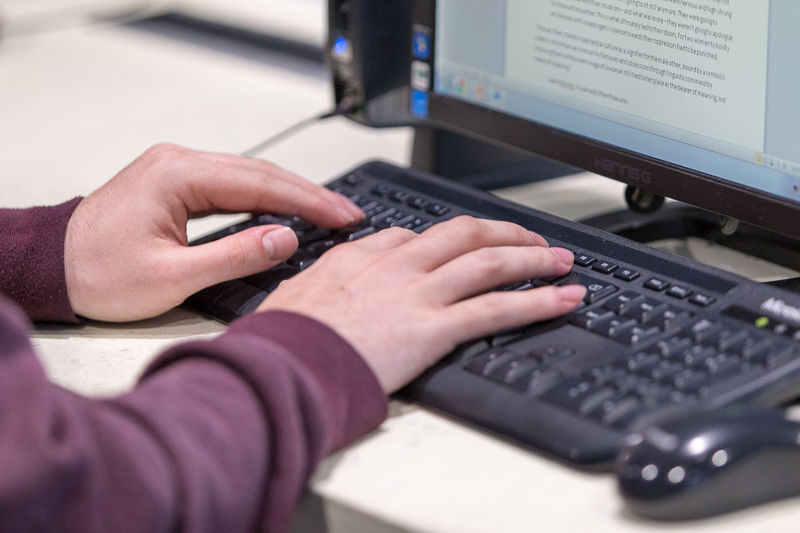 Close up of someone typing on a laptop