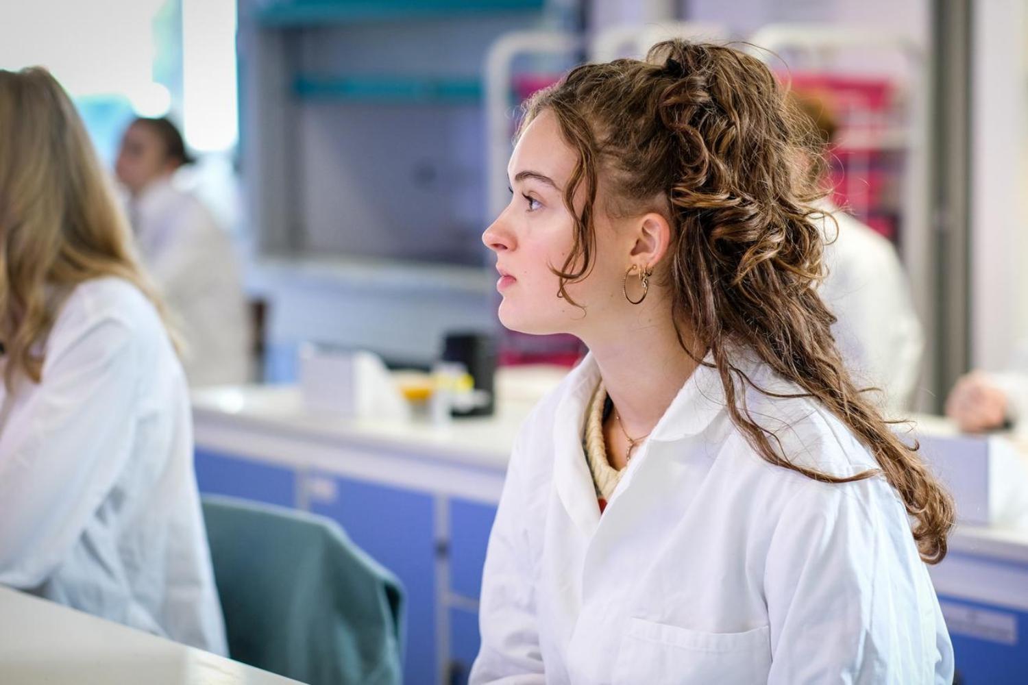 A person sitting at a bench in a science lab