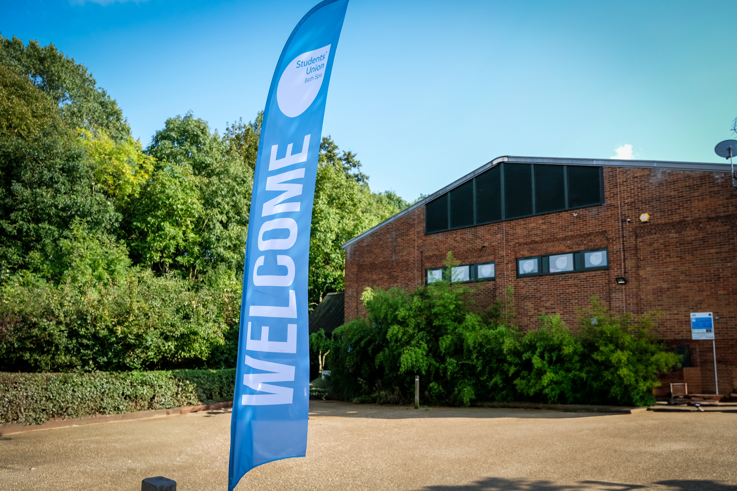 A building in the background with a blue welcome banner in the foreground