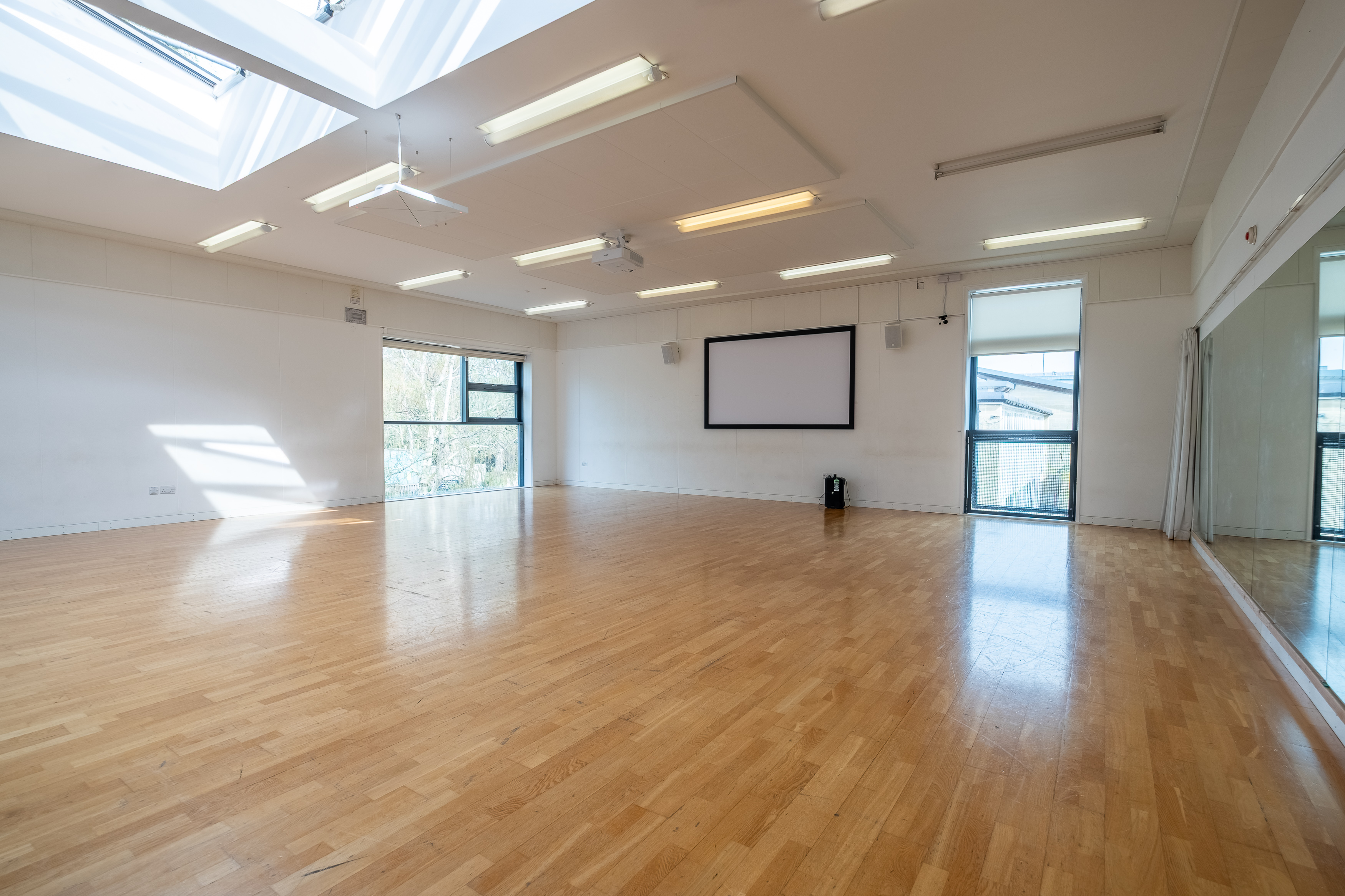 A large empty dance studio with skylights flooding the room with natural daylight