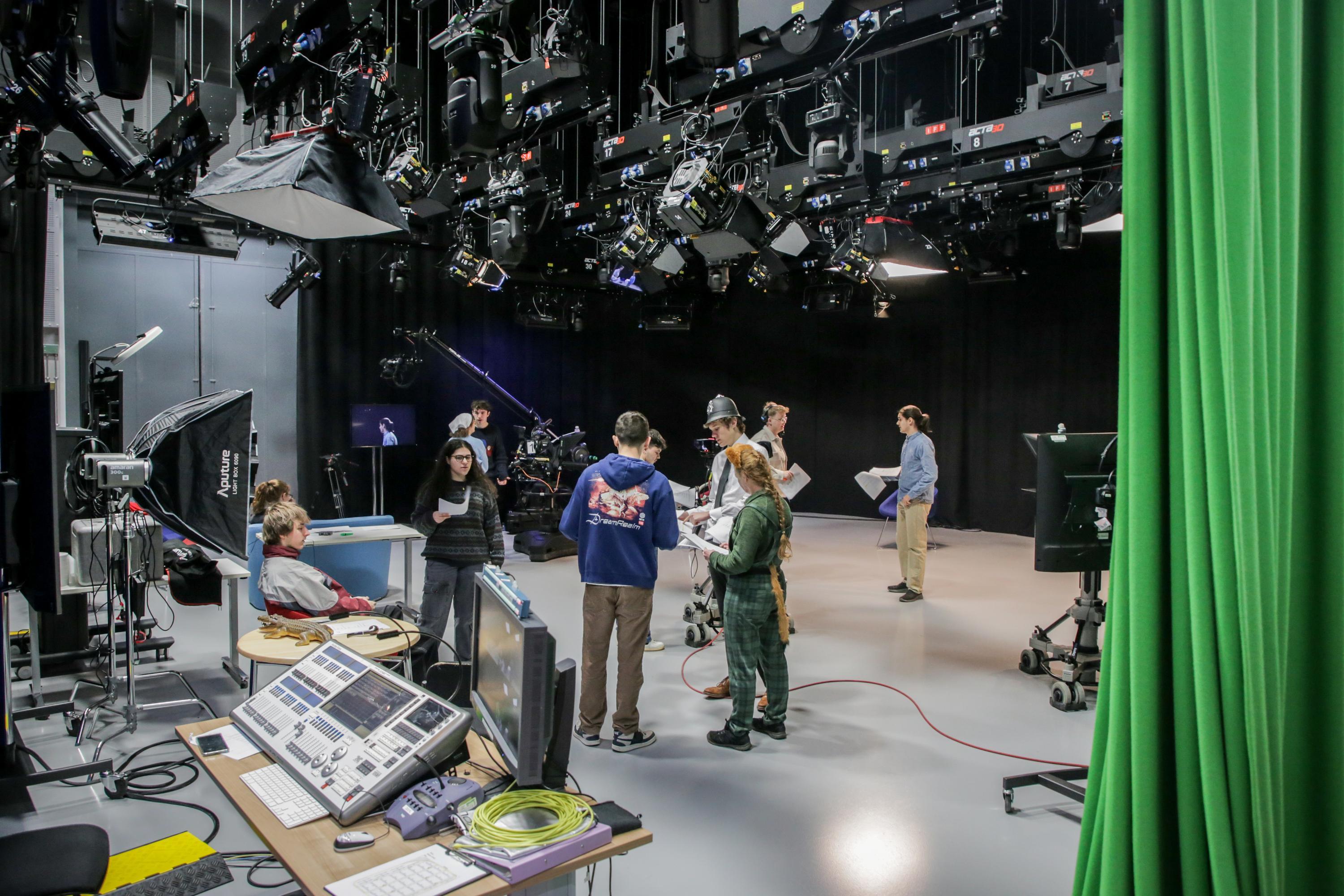 A large TV studio filled with complex technical equipment and cast and crew