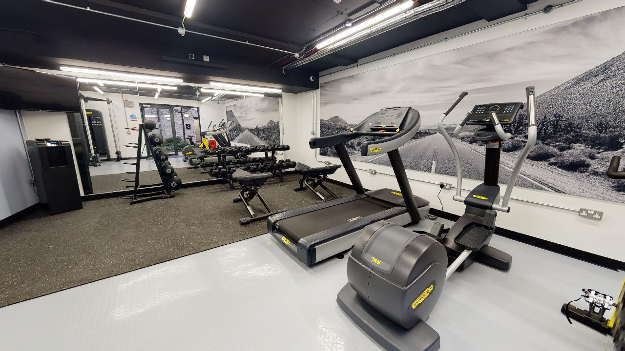 An on-site gym with various types of equipment lined up