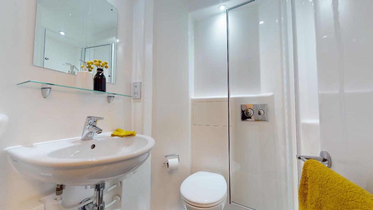 A basic bathroom with toilet, shower and sink