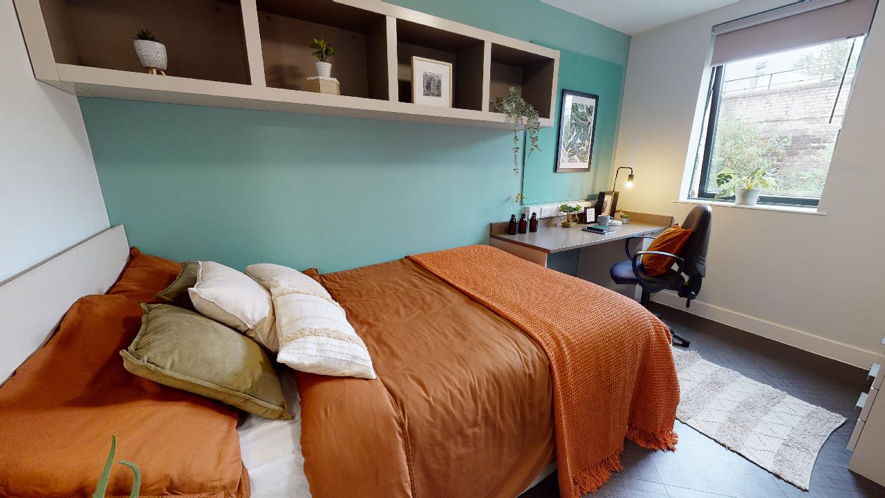 A student bedroom with a bed, desk and chair