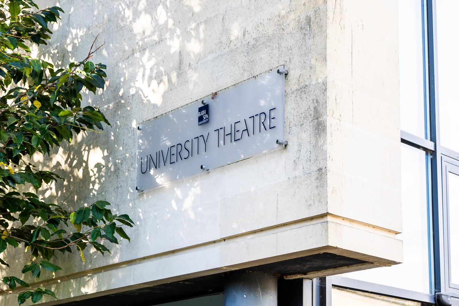 A light-coloured stone building with a sign reading University Theatre in capital letters
