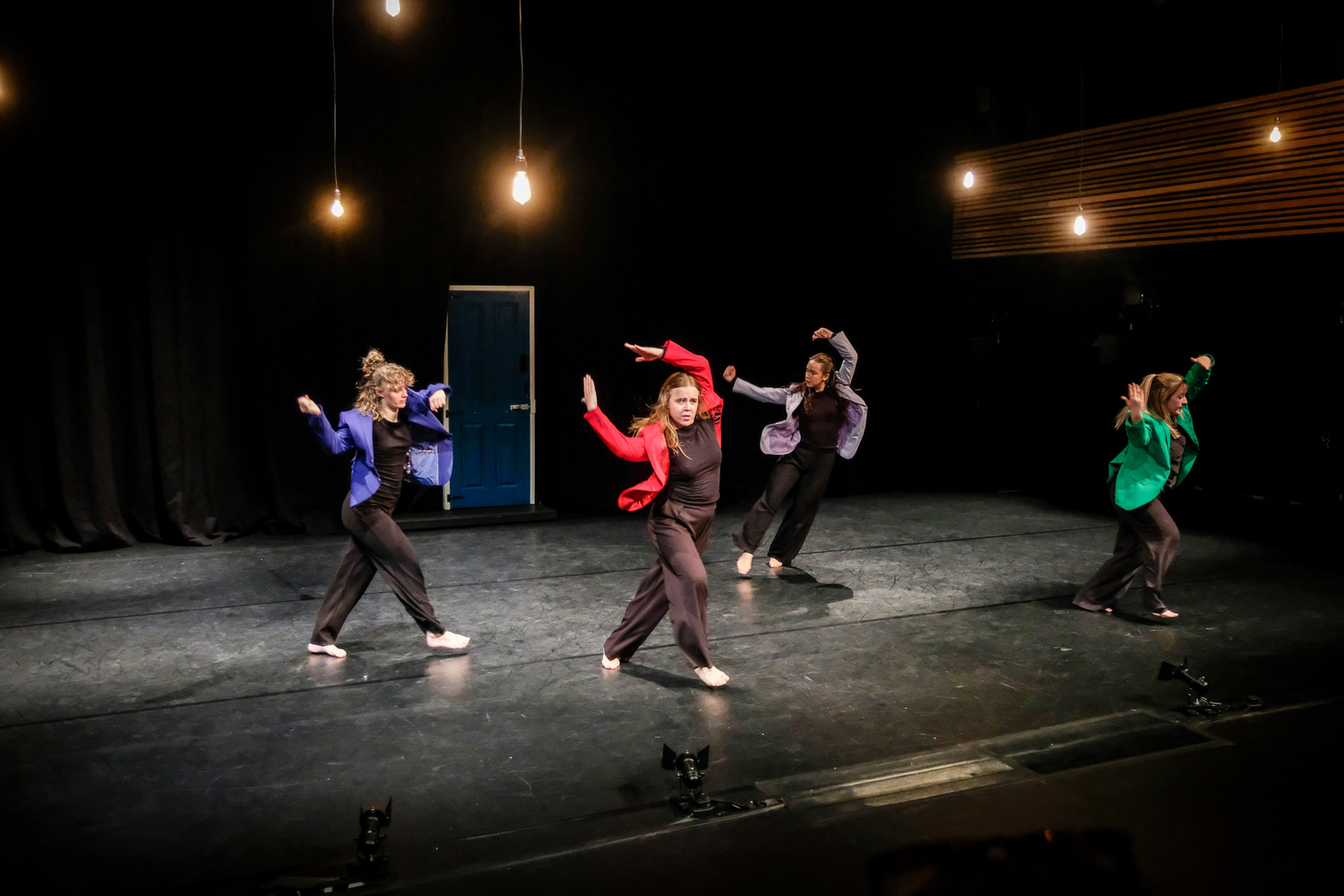 Four dancers on stage during a performance