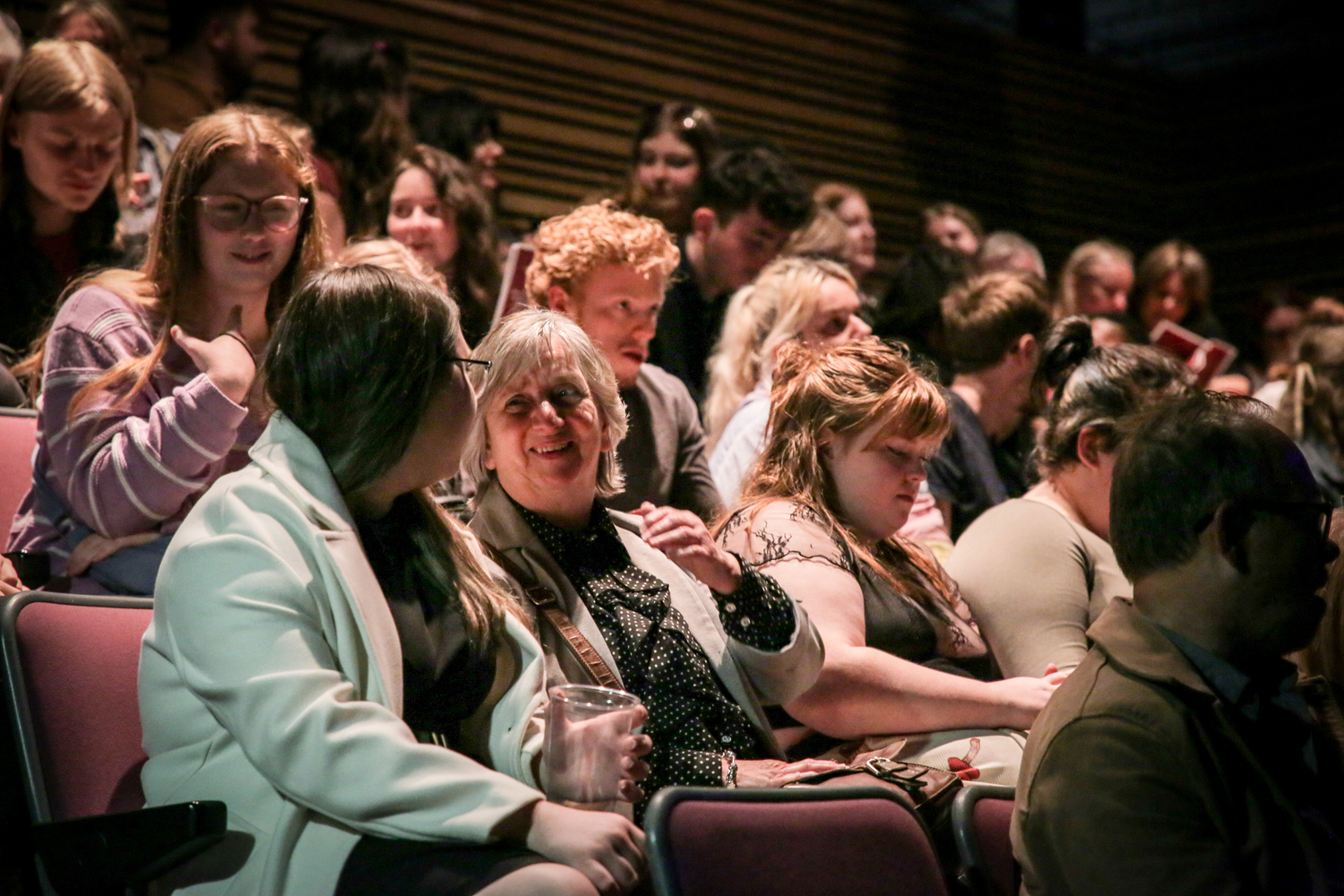 An engaged audience talking during an interval at a theatre performance