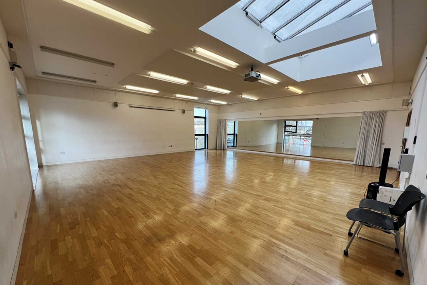 A large empty dance studio with skylights flooding the room with natural daylight
