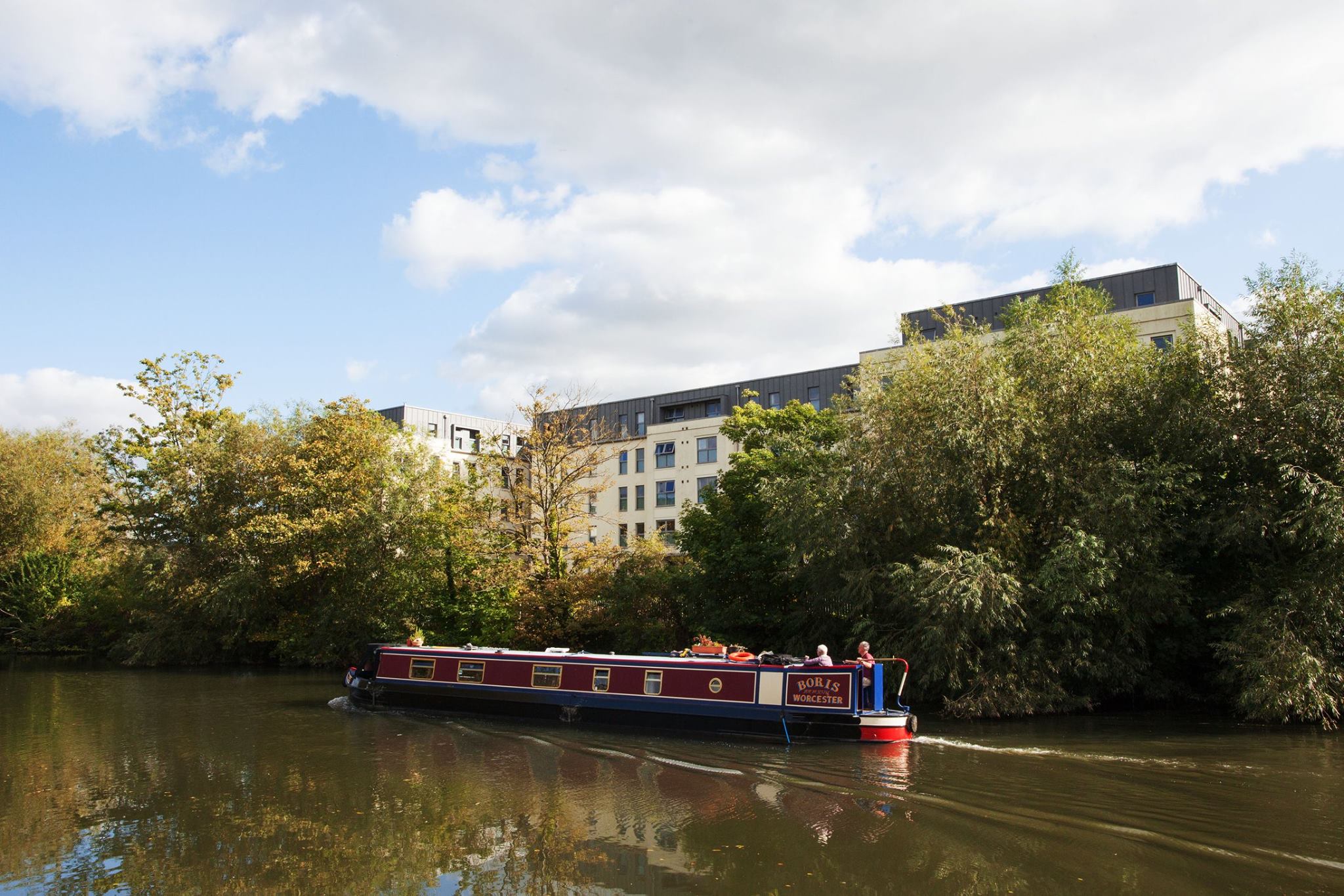 A canal boat sailing past a student accommodation block