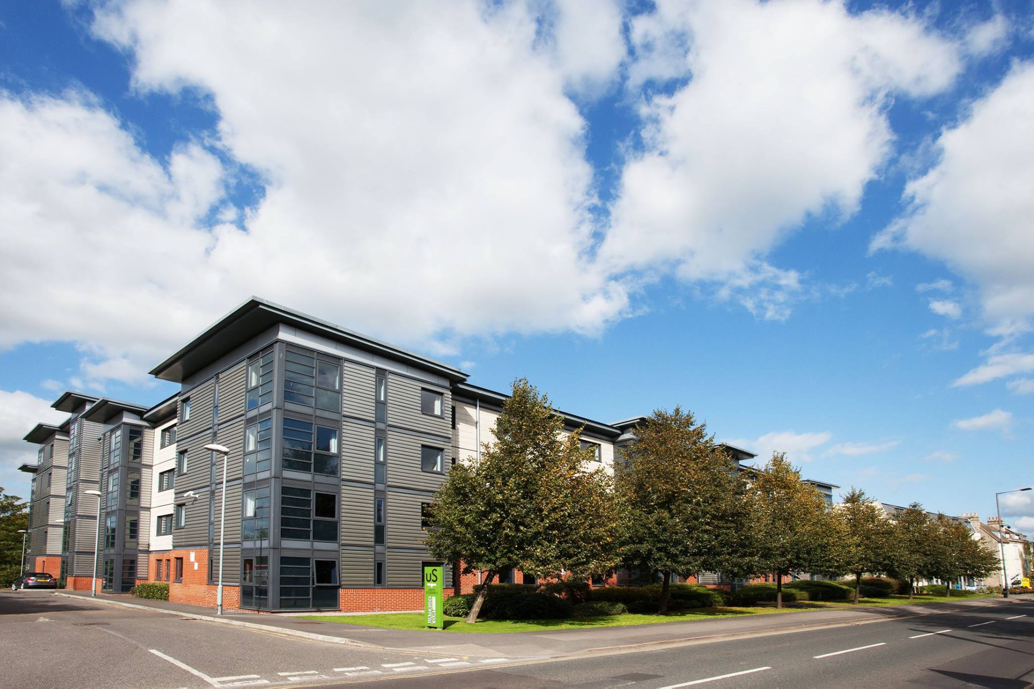 A student accommodation blocks situated next to a road lined with trees