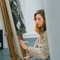 A Bath Spa student painting on canvas.