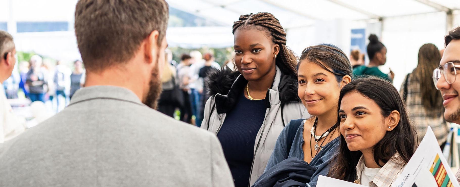 Group of students chatting an employer at a jobs fair