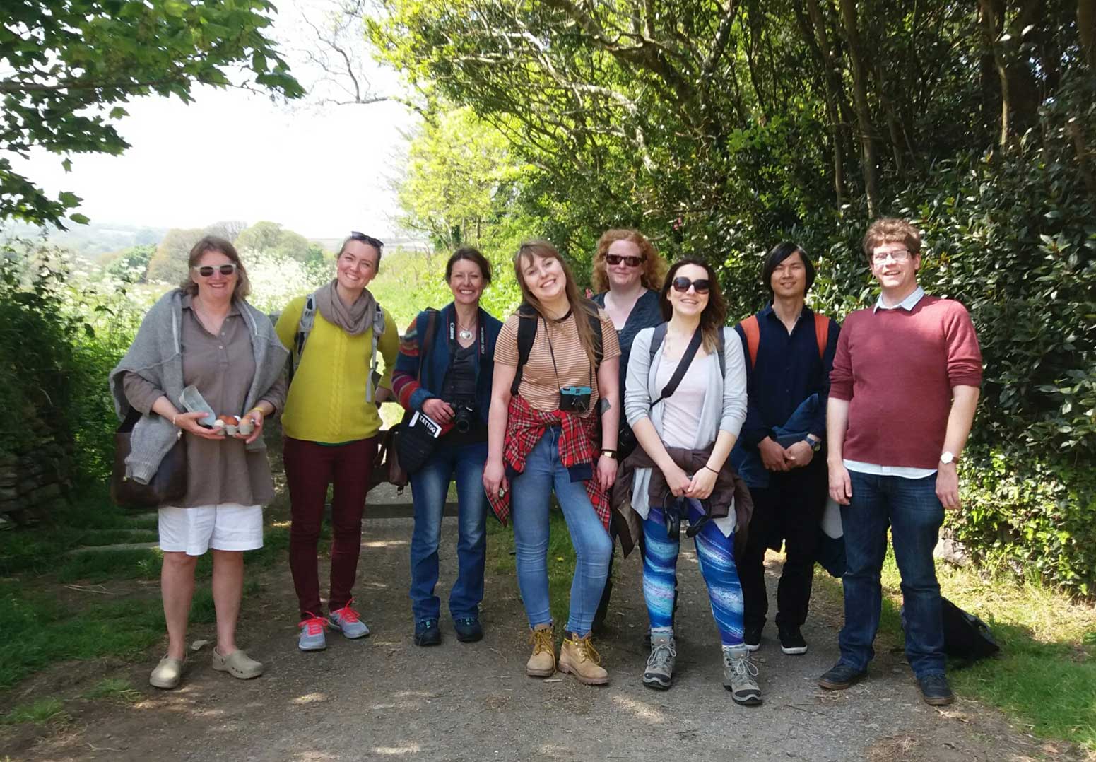 A group of people stand in front of a countryside backdrop