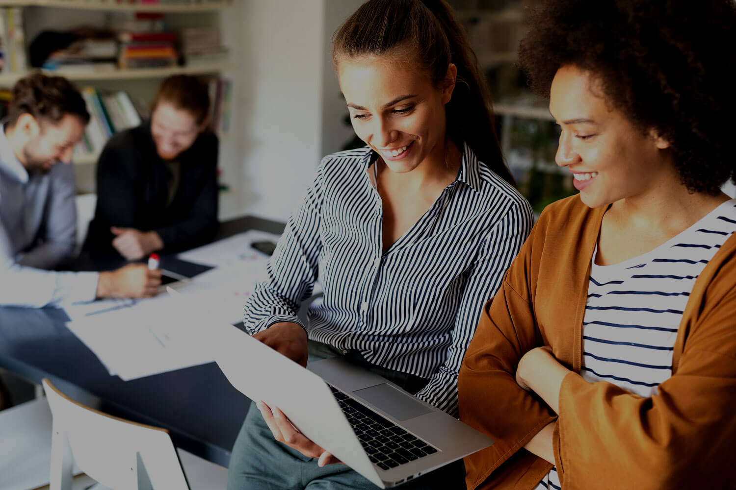 Two women working together at a laptop