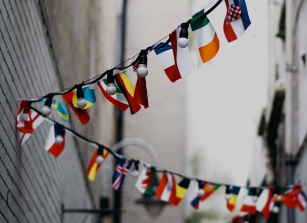 International flags threaded through an alleyway on a strand of lights
