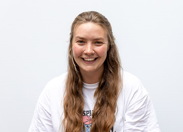 Person with long light brown hair smiling