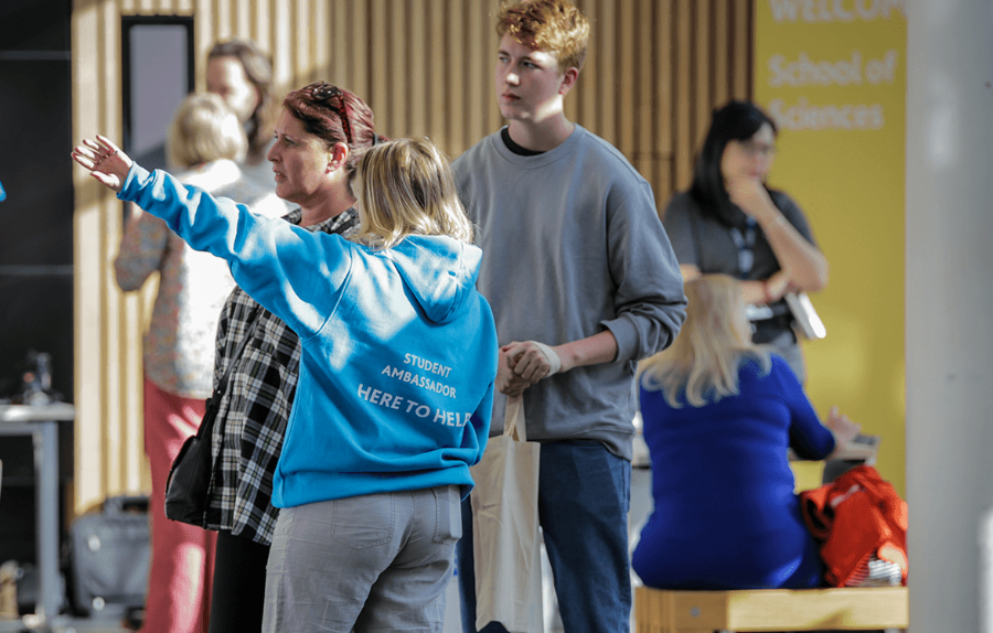 a student ambassador gives a family at an open day directions