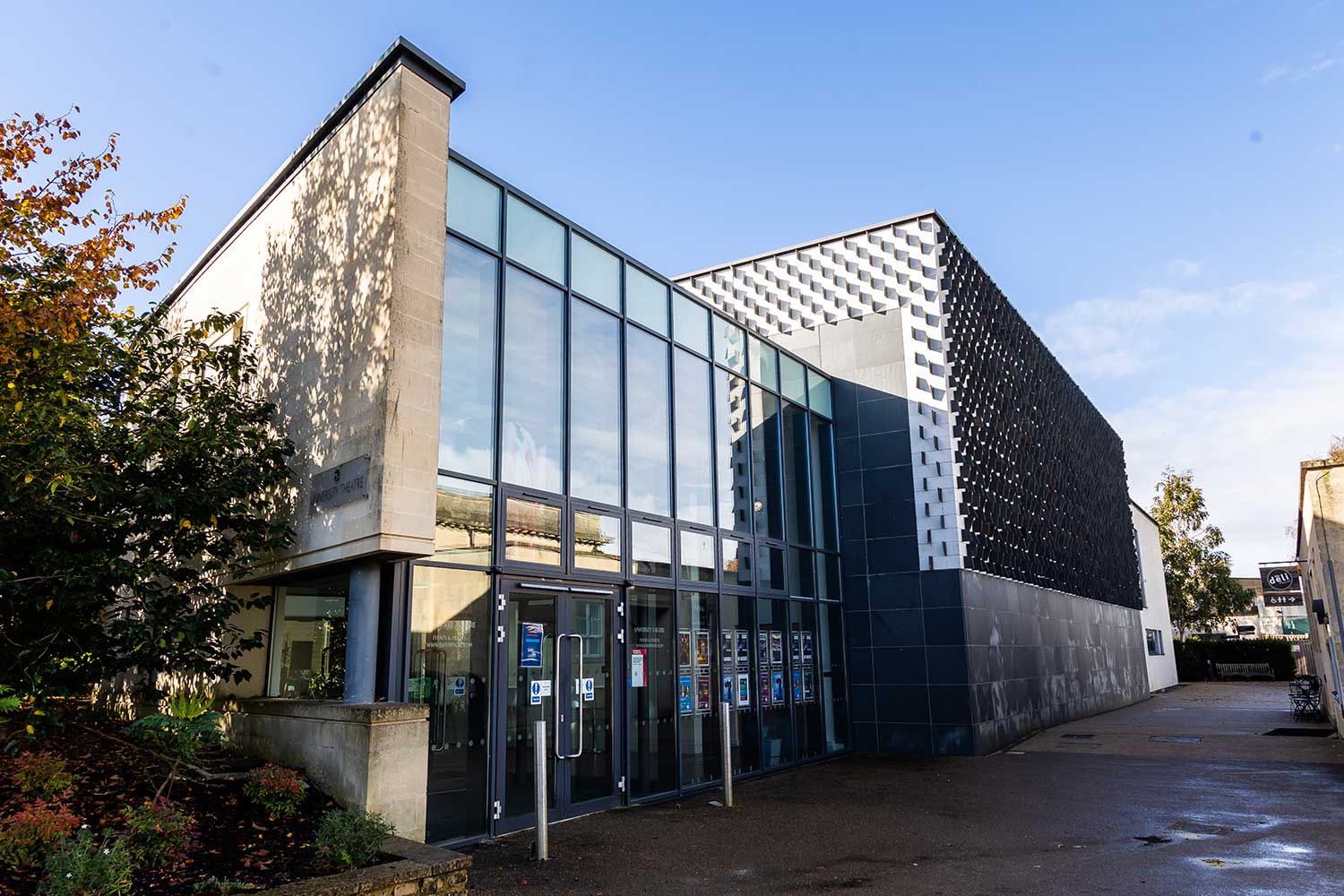 A sharp, geometric building reflecting sunlight in its glass windows