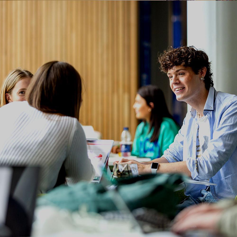 A smiling group of students study together