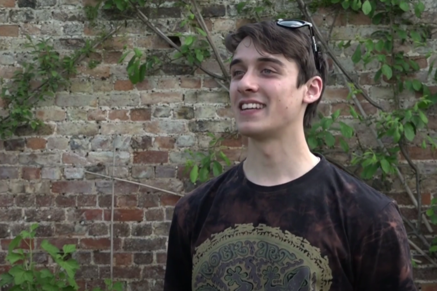 A student stands in the Wall Garden for an interview